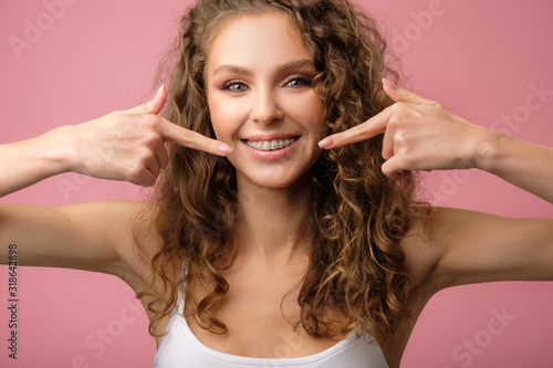Quadro em tela Attractive girl with curly hair isolated on pink