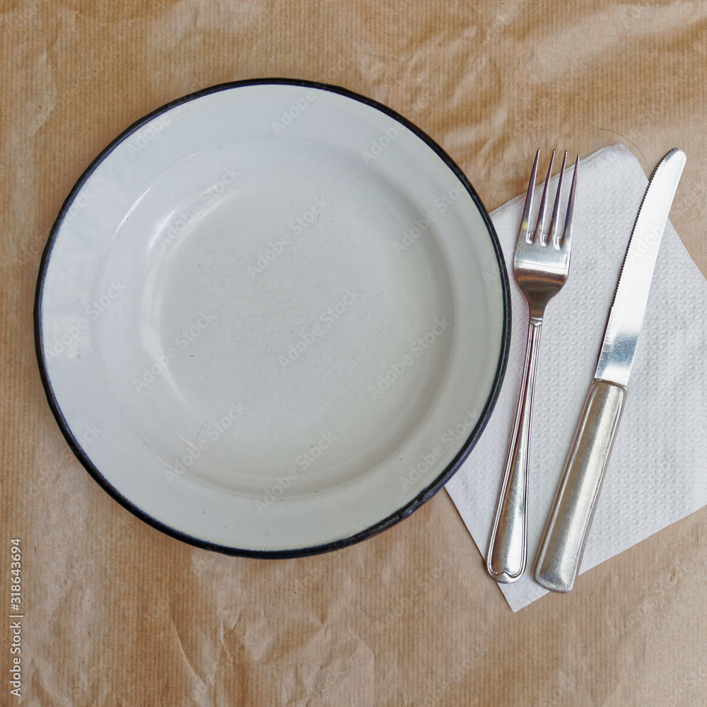 waiting to be served, empty dish, fork and knife on grunge brown serving paper top view waiting to be served, empty dish, fork and knife on grunge brown serving paper top view