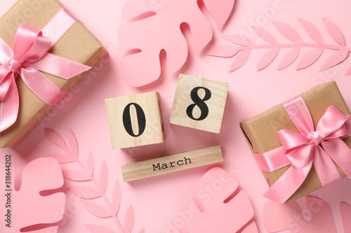 Decorative palm leaves, gifts and calendar on pink background, top view