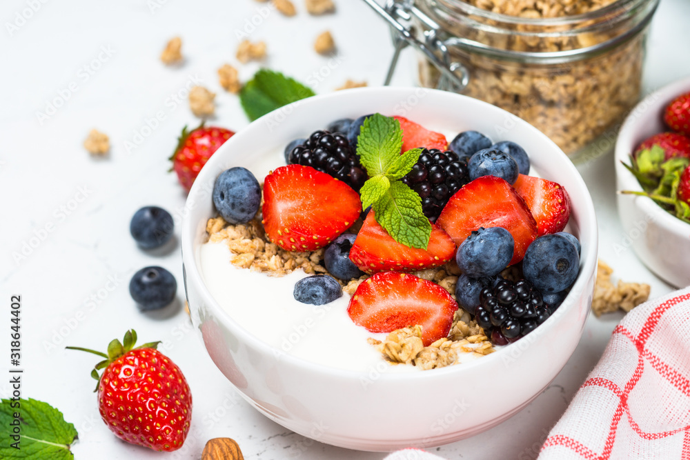 Greek yogurt granola with fresh berries on white table. Greek yogurt granola with fresh berries on white table.