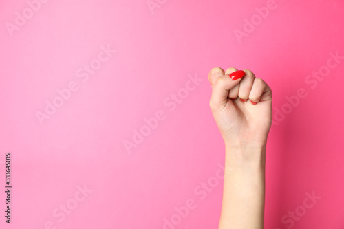 Woman hand with red nails on pink background, space for text