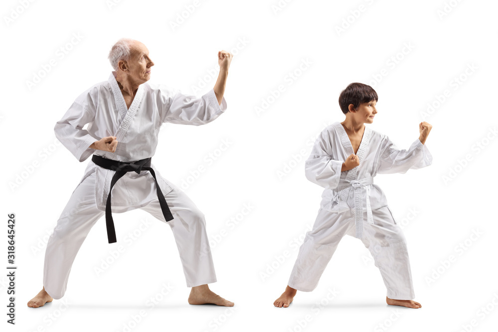 Boy and a senior man in kimonos practicing karate Boy and a senior man in kimonos practicing karate
