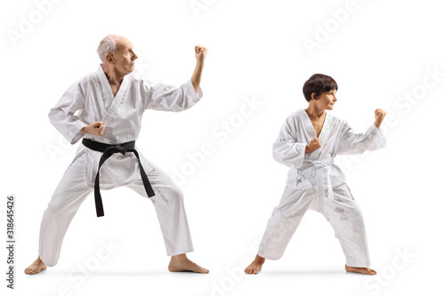 Boy and a senior man in kimonos practicing karate