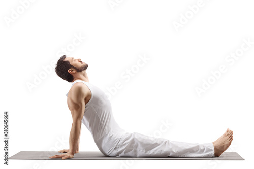 Fototapeta Naklejka Na Ścianę i Meble -  Man on a floor mat doing a yoga stretch