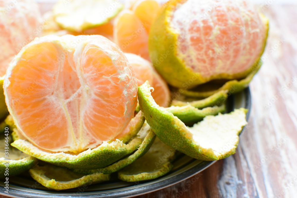  Natural, whole, chopped tangerines on wooden background