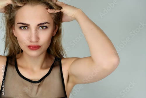 Cosmetics concept, girl face skin care on white background. A close-up portrait of a pretty Caucasian blonde model with long hair with excellent facial skin and good makeup.