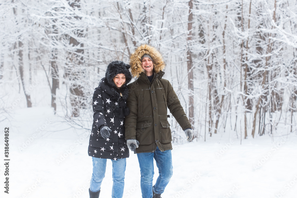 Happy loving couple having fun outdoors in snow park. Winter vacation