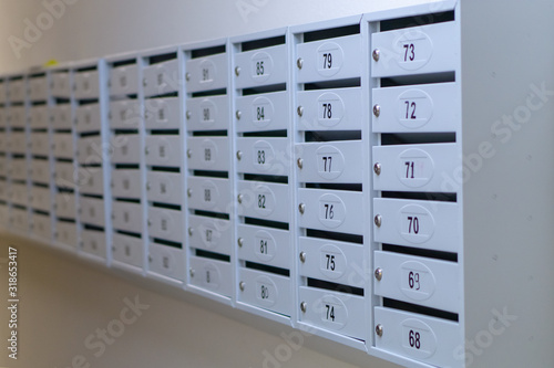 gray mailboxes with numbers on the wall