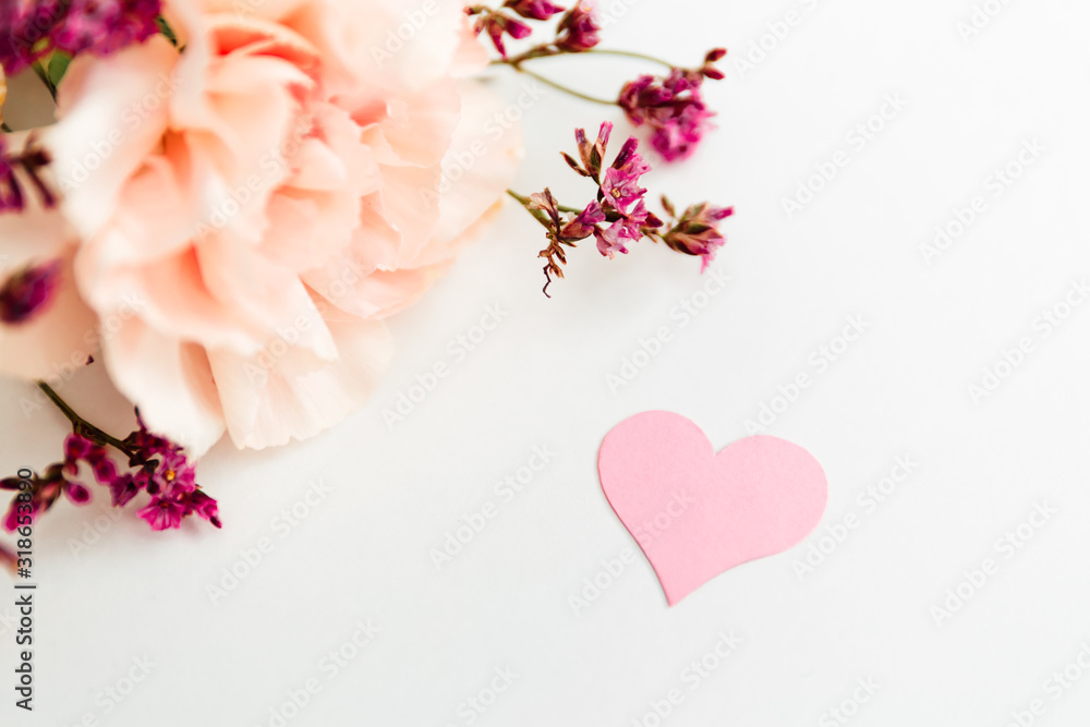 bouquet of flowers on the white background with pink paper heart symbol of love bouquet of flowers on the white background with pink paper heart symbol of love