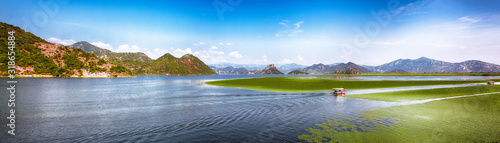 Awesome view of Skadar lake surrounded by green mountain peaks on a sunny day. photo