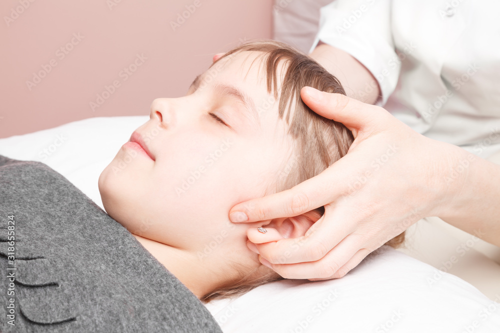 Girl receiving osteopathic treatment of her head Girl receiving osteopathic treatment of her head