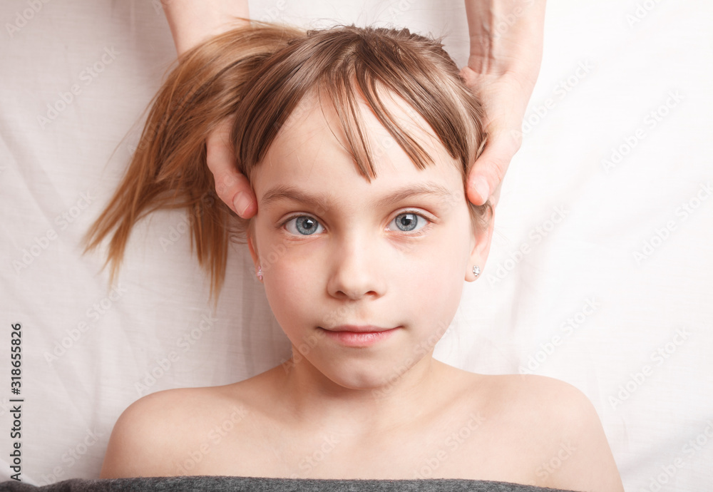 Girl receiving osteopathic treatment of her head Girl receiving osteopathic treatment of her head