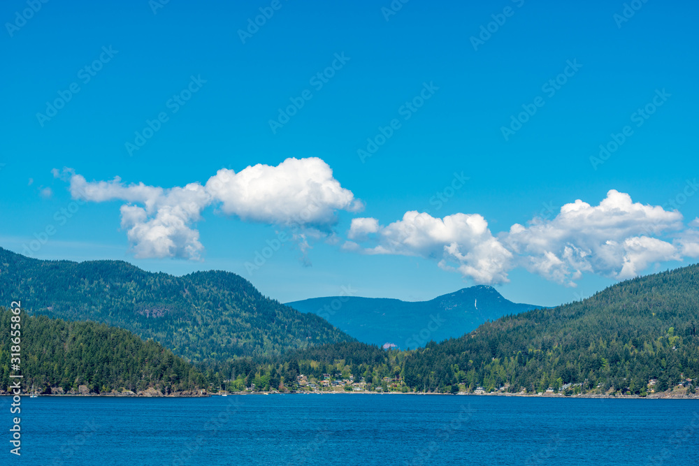 View over inlet, ocean and island with boat and mountains in beautiful British Columbia. View over inlet, ocean and island with boat and mountains in beautiful British Columbia.