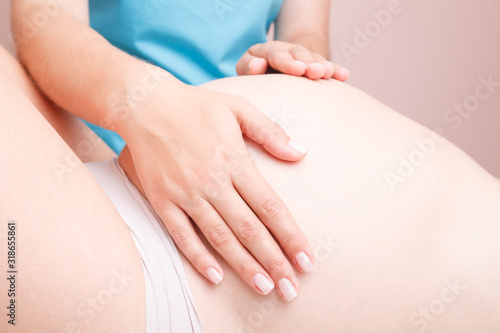 Wallpaper Mural Pregnant woman receiving osteopathic treatment of her belly Torontodigital.ca