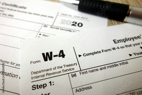 Blank W-4 form and a pen. Tax season
