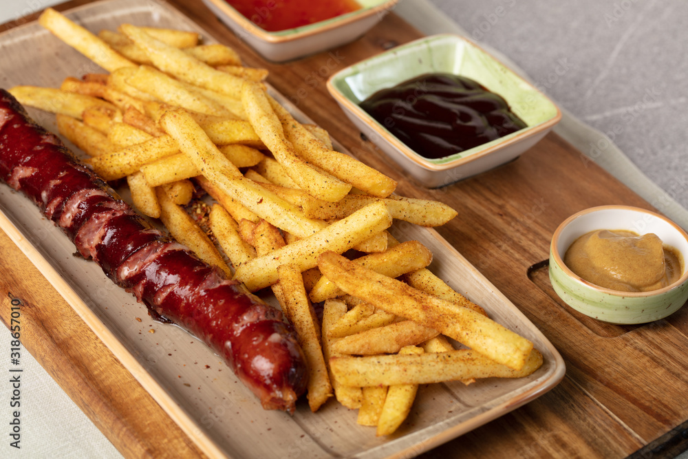Fried sausage with french fries served on plate Fried sausage with french fries served on plate