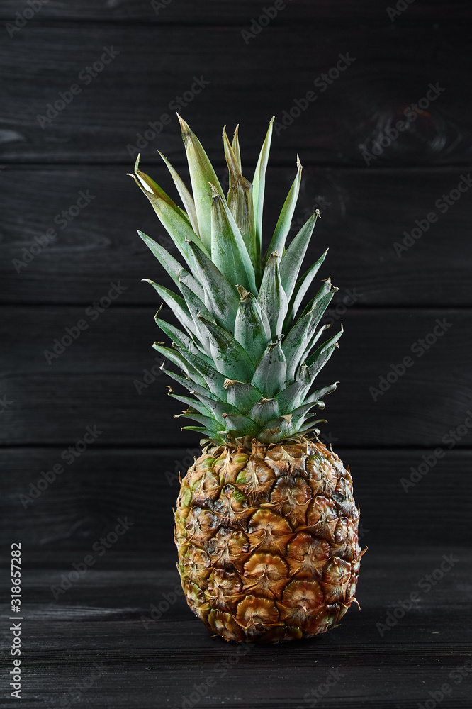 ripe pineapple on a black wooden background, food photography