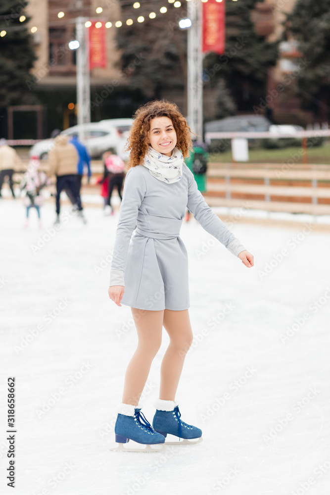 Beautiful curly girl riding in the skate rink