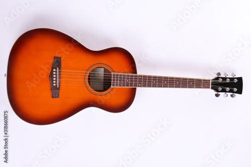 Folk style parlor acoustic guitar isolated on white background with a lot of copy space for text. Studio shot of travel size musical instrument. Close up.