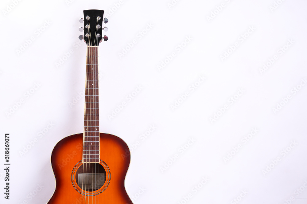 Folk style parlor acoustic guitar isolated on white background with a lot of copy space for text. Studio shot of travel size musical instrument. Close up.