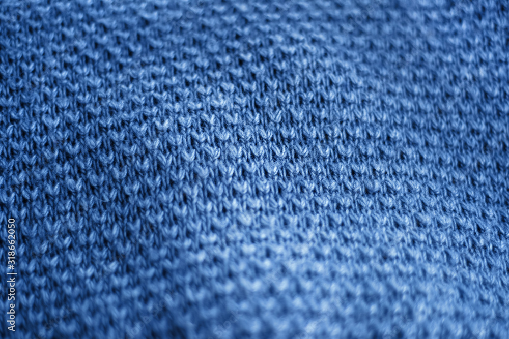 Full frame of folded blue knitted wool sweater cloth as backdrop. Horizontal classic blue background pattern. Copy space for text. Design. Cover. Full frame of folded blue knitted wool sweater cloth as backdrop. Horizontal classic blue background pattern. Copy space for text. Design. Cover.