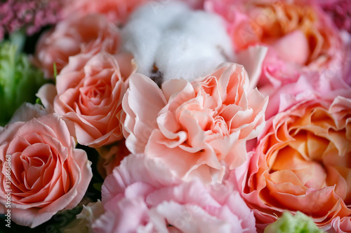 Delicate bouquet of eustomas, carnations, cotton, spray roses and David Austin roses, in pink and beige colors.