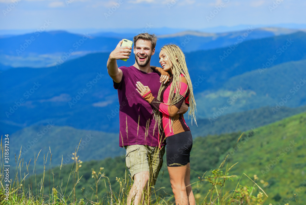 Lets take photo. Capturing beauty. Man and woman posing mobile photo. Couple taking photo. Summer vacation concept. Young adventurers. Travel together with darling. Couple in love hiking mountains