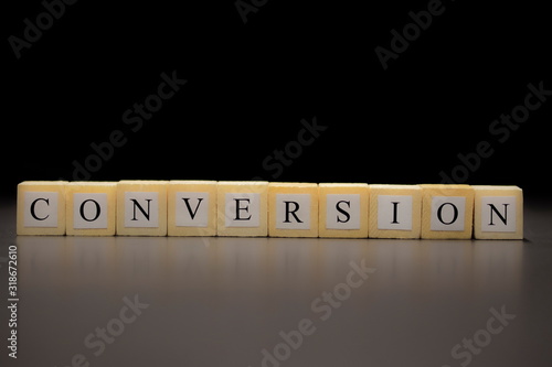 Obraz na plátne The word CONVERSION written on wooden cubes isolated on a black background