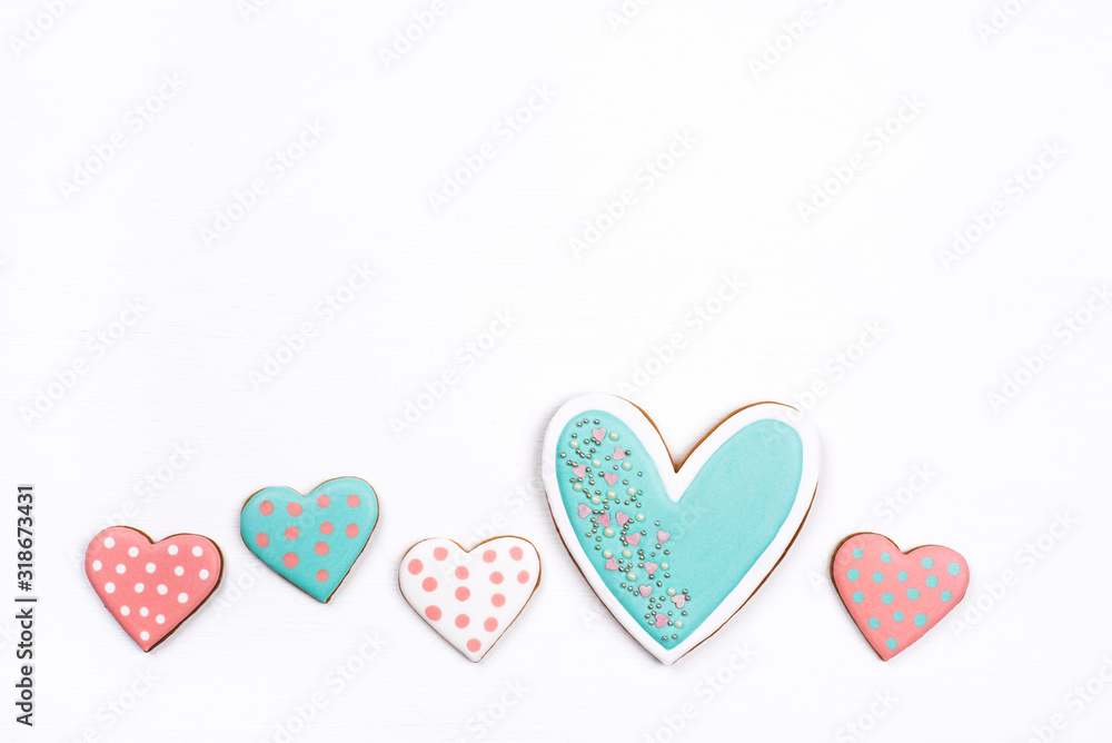 Gingerbread cookies with frosting in the shape of a heart on white background. Valentines day concept. Flat lay, top view, copy space for text.