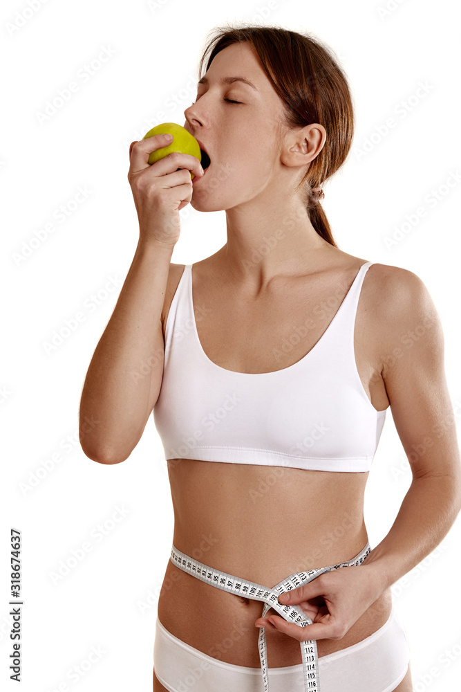 Perfect, slim, young body of a girl in white underwear. The girl measures the waist. Weight loss and healthy eating. The problem of anarexia. Plastic surgery. Perfect, slim, young body of a girl in white underwear. The girl measures the waist. Weight loss and healthy eating. The problem of anarexia. Plastic surgery.
