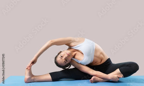 Fototapeta Naklejka Na Ścianę i Meble -  Young beautiful woman doing Yoga on the floor
