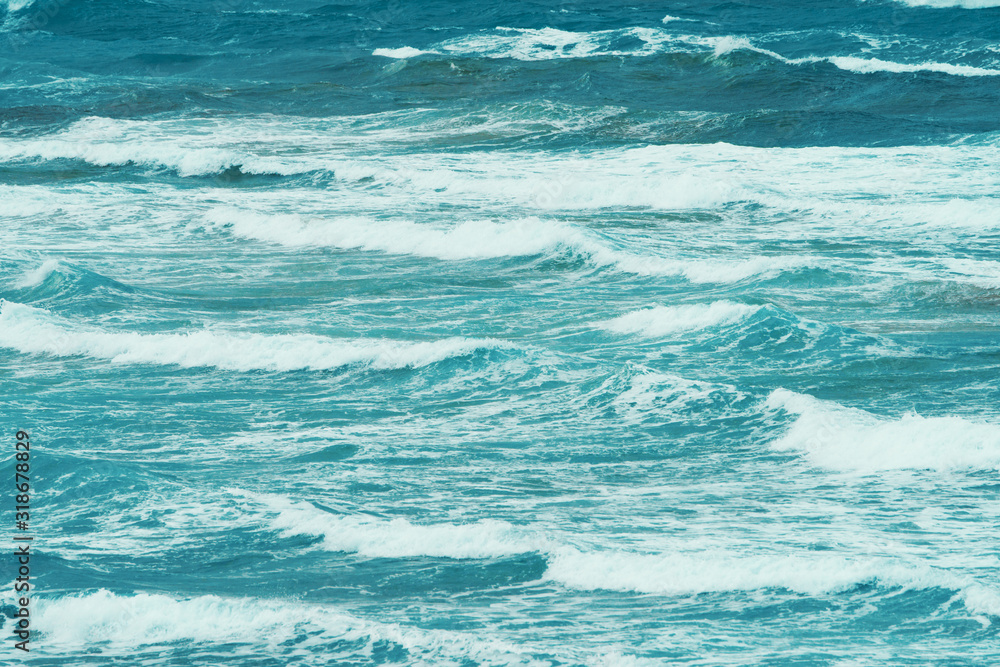 Photography of oceanic shore. Soft waves and bright blue water surface. Natural background. Concepts of beauty in nature and tourism and touristic time.. Photography of oceanic shore. Soft waves and bright blue water surface. Natural background. Concepts of beauty in nature and tourism and touristic time..