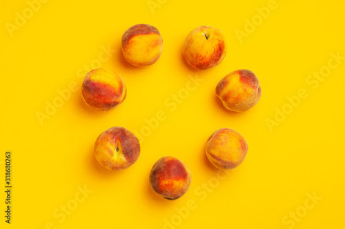Flat lay composition with peaches. Ripe juicy peaches scattered in the shape of circle on yellow background. Flat lay, top view, copy space. Fresh organic fruit, vegan food. Fruit Background