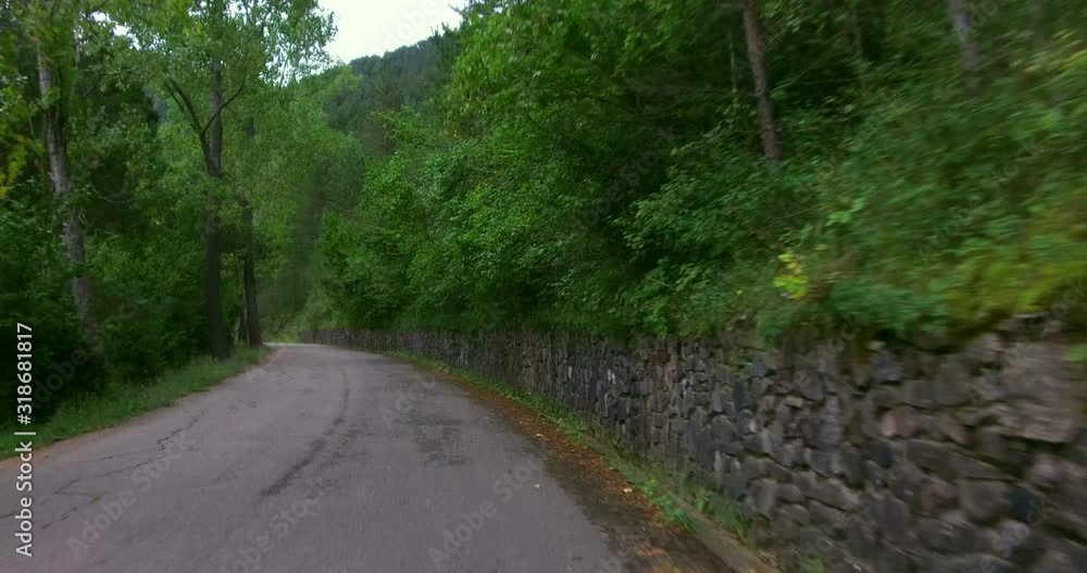 Driving quietly on a lonely mountain road (vehicle shot). Crossing a forest located in the Pyrenees of Catalonia, Spain, from the driver's point of view Driving quietly on a lonely mountain road (vehicle shot). Crossing a forest located in the Pyrenees of Catalonia, Spain, from the driver's point of view