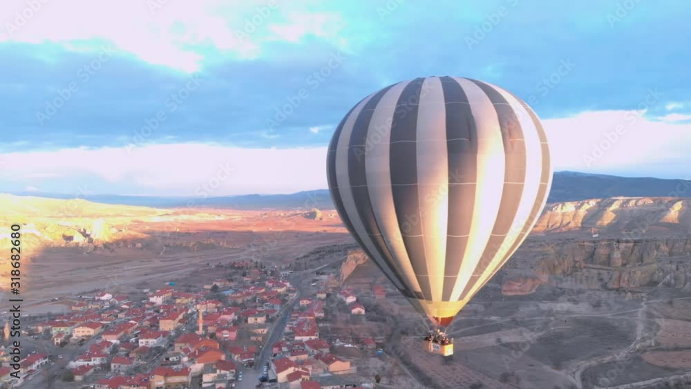Alone Hot Air Balloon flying freely over the valley between mountains at Cavusin region of Cappadocia, Turkey Alone Hot Air Balloon flying freely over the valley between mountains at Cavusin region of Cappadocia, Turkey