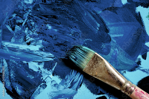 Blue paints on palette with artist paint brush