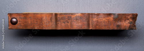 Rusty metal plate on wooden background.Cooper plate.