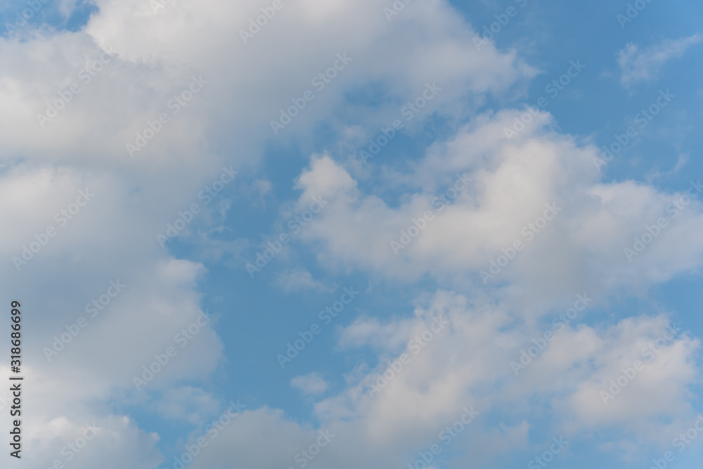 Blue sky full of white fluffy clouds, shot at bright sunny summer day. Relax and calm time. 