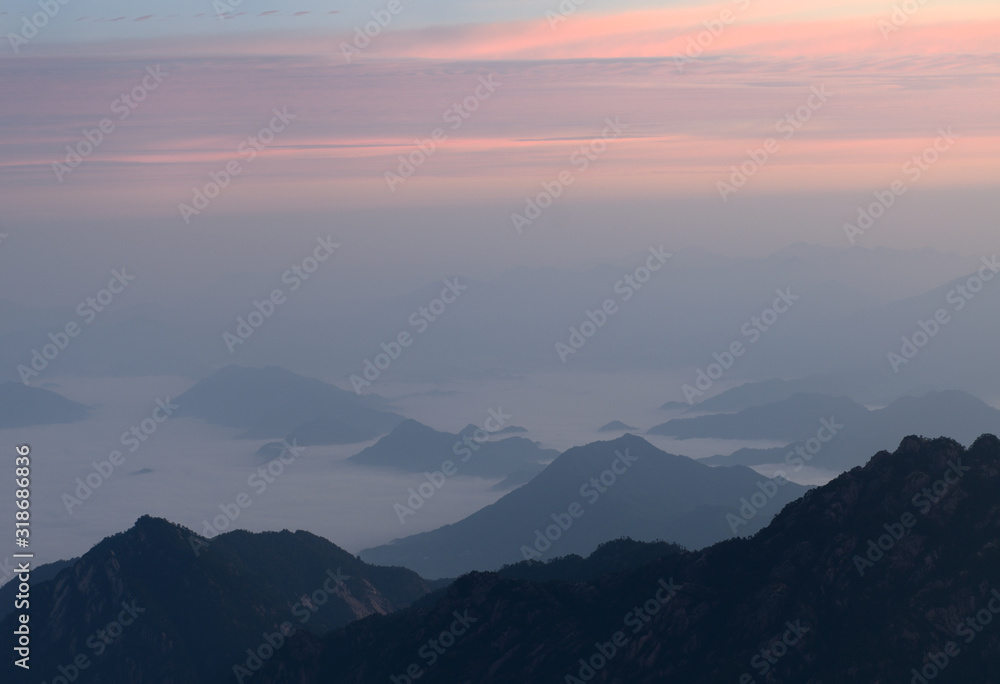 Pink glow at sunrise with fog in valley at North Sea area Huangshan Mountain China