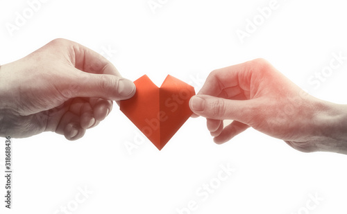 Red heart in woman and man hands. Black and white image on isolated white background. Concept of love, giving gifts, donorship.