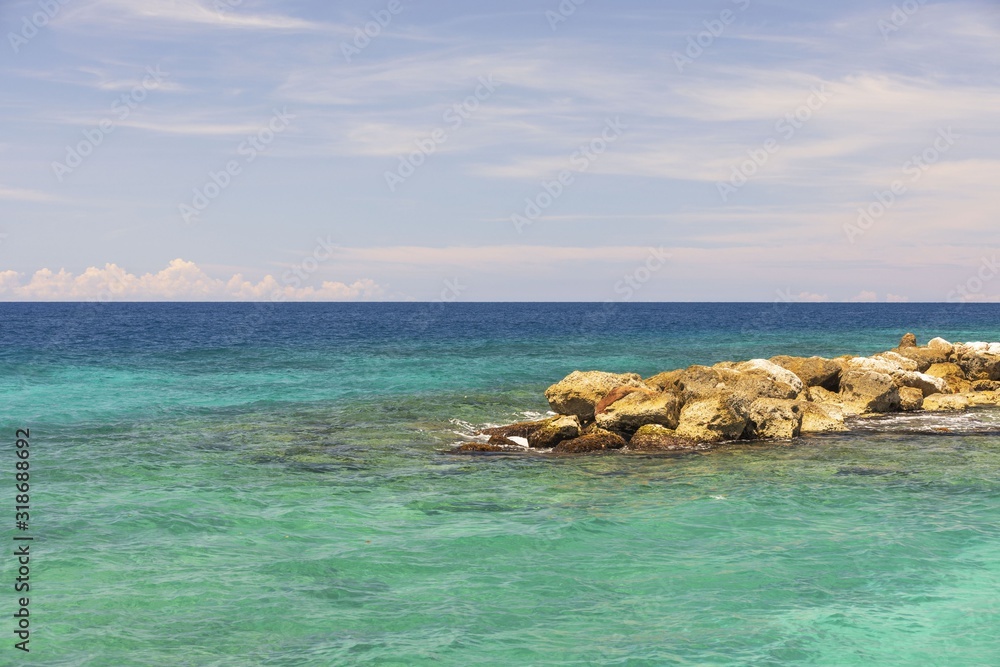 Amazing view of turquoise water of Atlantic ocean and blue sky with white clouds. Curacao island.. Beautiful nature background. Amazing view of turquoise water of Atlantic ocean and blue sky with white clouds. Curacao island.. Beautiful nature background.