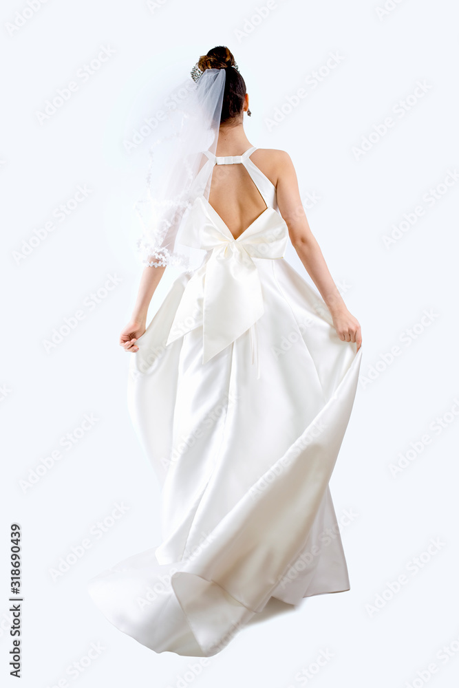 View from behind to a beautiful bride in pure white dress. Young woman in bride's dress. Family, love ceoncepts. Isolated on gray View from behind to a beautiful bride in pure white dress. Young woman in bride's dress. Family, love ceoncepts. Isolated on gray
