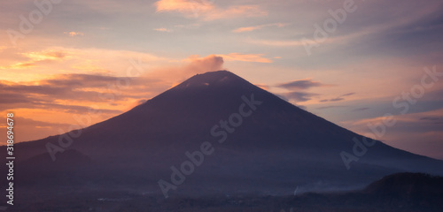 Beautiful landscape volcano mountain Agung silhouette on Bali at sunset with orange sunset sky in Indonesia