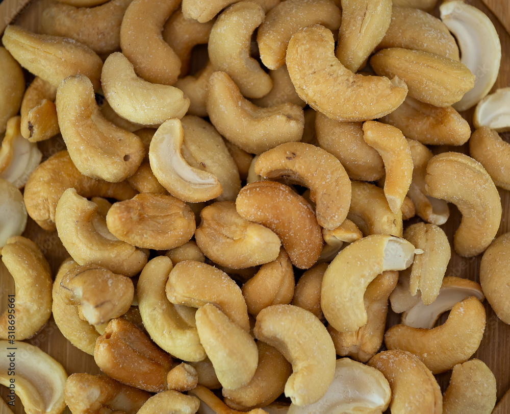 Cashews Nut or cashewkerne nuts group Protein and healthy food for diet in a wooden plate on a black background. Cashews Nut or cashewkerne nuts group Protein and healthy food for diet in a wooden plate on a black background.