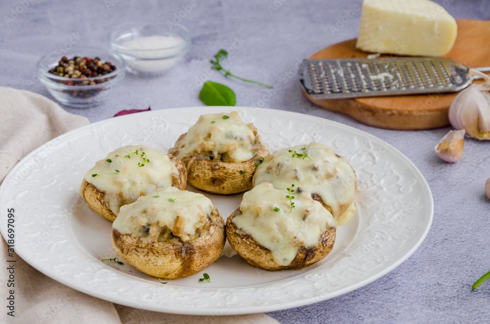 Baked Stuffed mushrooms with onion, cream, garlic, thyme and cheese on a white plate. Horizontal orientation. Baked Stuffed mushrooms with onion, cream, garlic, thyme and cheese on a white plate. Horizontal orientation.