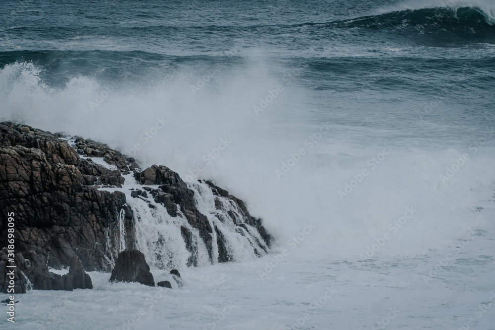 Fototapeta premium The waves of the ocean hit the rocks with small splashes