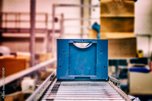 Tablou pe pânză Blue boxes in a large, fully automated logistics warehouse run on a conveyor belt