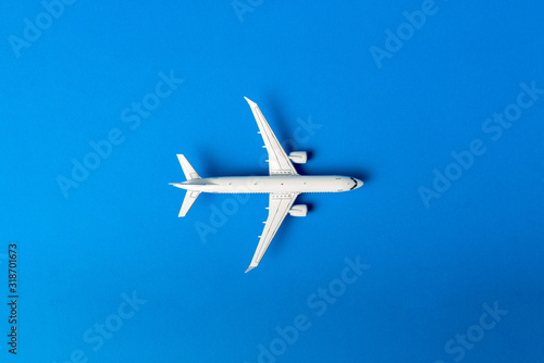 The passenger plane on blue background with empty space for text. Top view, copy space