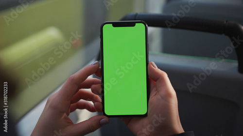 Lviv, Ukraine - May 19, 2018: Hands use touch holding a mobile telephone with a vertical green screen in tram chroma key smartphone technology cell phone street touch message display hand
