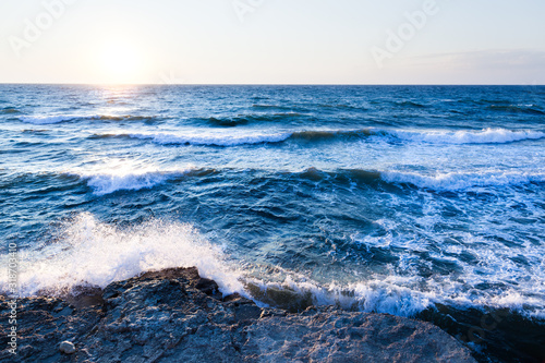Beautiful blue sunset and water stones over Black sea rocky coastline in Crimea on summer day. Natural landscape background and wallpaper © YouraPechkin